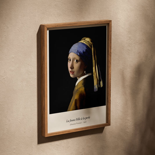 La Jeune Fille à la perle, Vermeer, affiche dans un cadre en chêne posé de biais sur un mur texturé