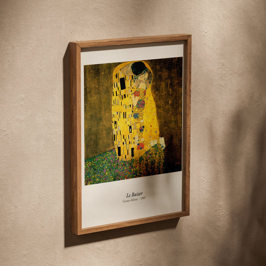Le Baiser, Gustav Klimt | Affiche Art Premium, affiche dans un cadre en chêne posé de biais sur un mur texturé