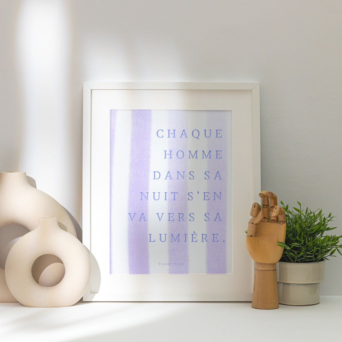 Affiche citation Victor Hugo - Chaque homme dans sa nuit, affiche encadrée posée près d'un vase blanc, lumière rasante