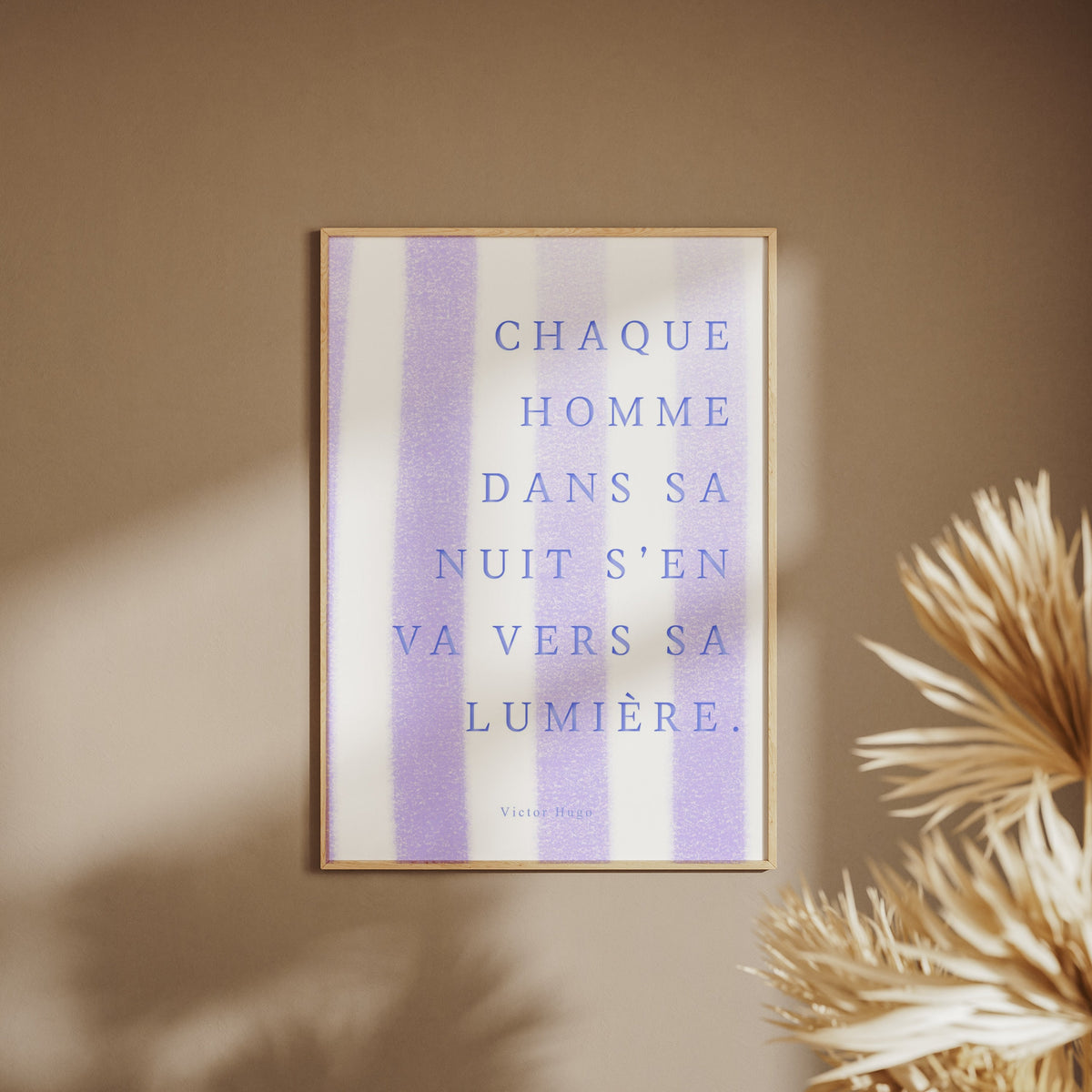 Affiche citation Victor Hugo - Chaque homme dans sa nuit, affiche encadrée sur un mur beige, pampas au premier plan