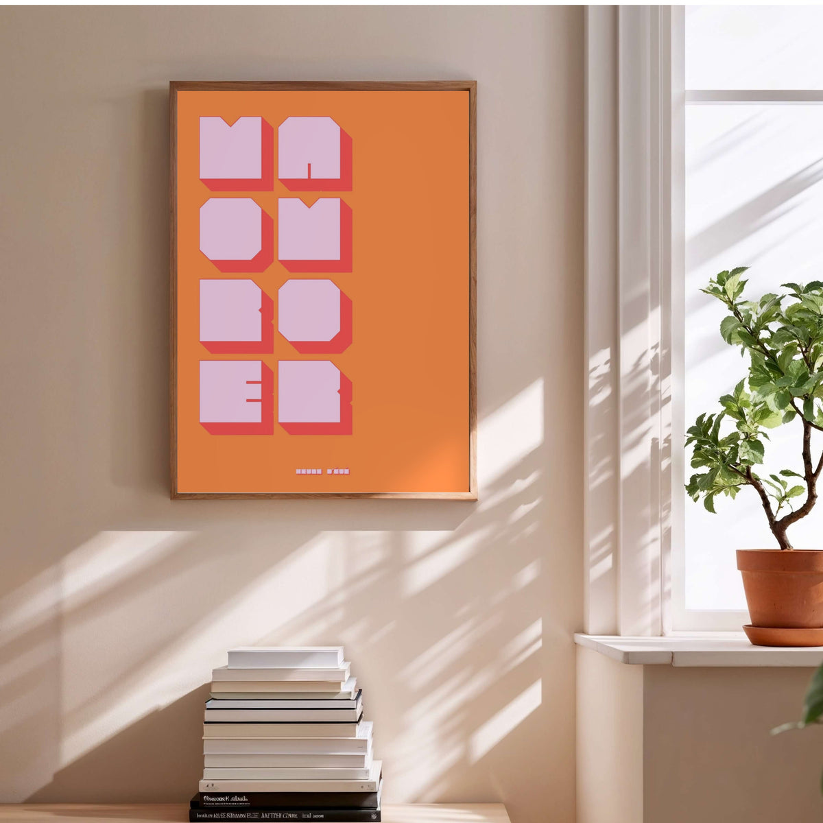 Affiche graphique More Amor, affiche encadrée au-dessus d'une pile de livres