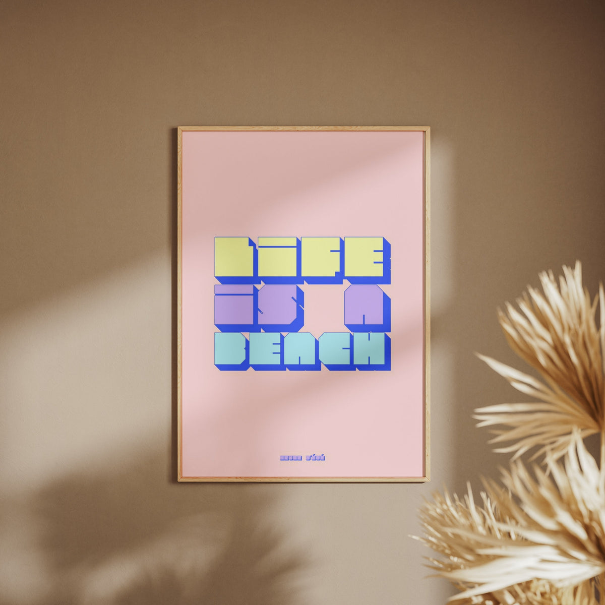 Life is a beach graphic poster, framed poster on a beige wall, pampas grass in the foreground