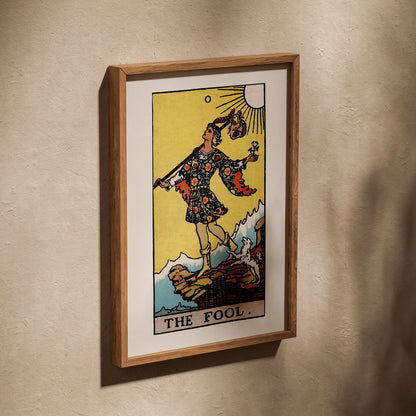 Le Mat - Arcane 0 du Tarot Rider-Waite, affiche dans un cadre en chêne posé de biais sur un mur texturé