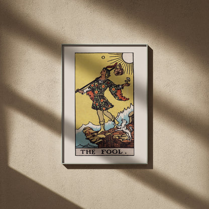 Le Mat - Arcane 0 du Tarot Rider-Waite, affiche encadrée sur un mur beige, ombres de fenêtre