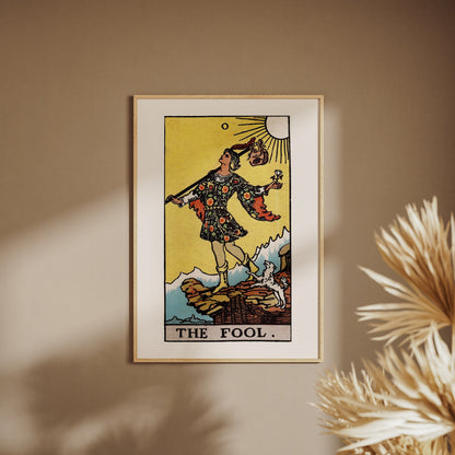 Le Mat - Arcane 0 du Tarot Rider-Waite, affiche encadrée sur un mur beige, pampas au premier plan