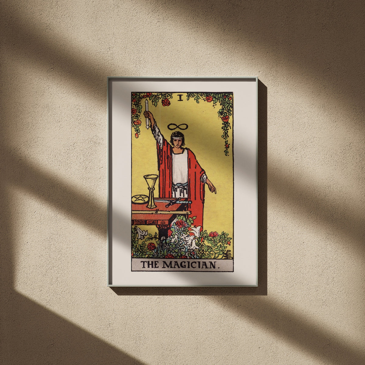 Le Bateleur - Arcane I du Tarot Rider-Waite, affiche encadrée sur un mur beige, ombres de fenêtre
