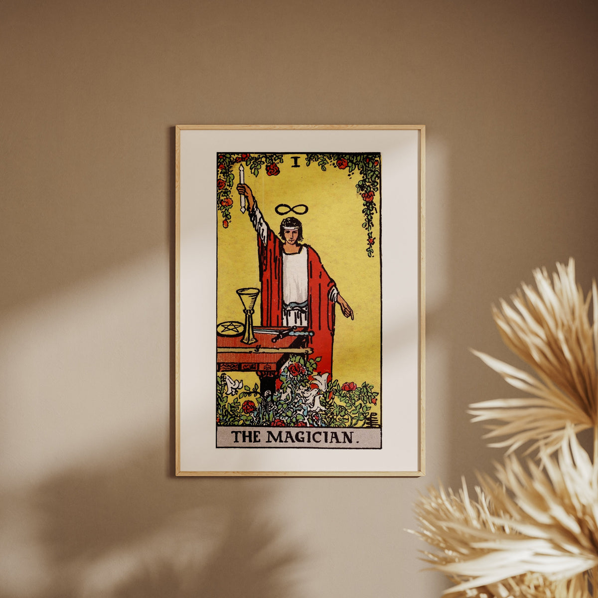 Le Bateleur - Arcane I du Tarot Rider-Waite, affiche encadrée sur un mur beige, pampas au premier plan