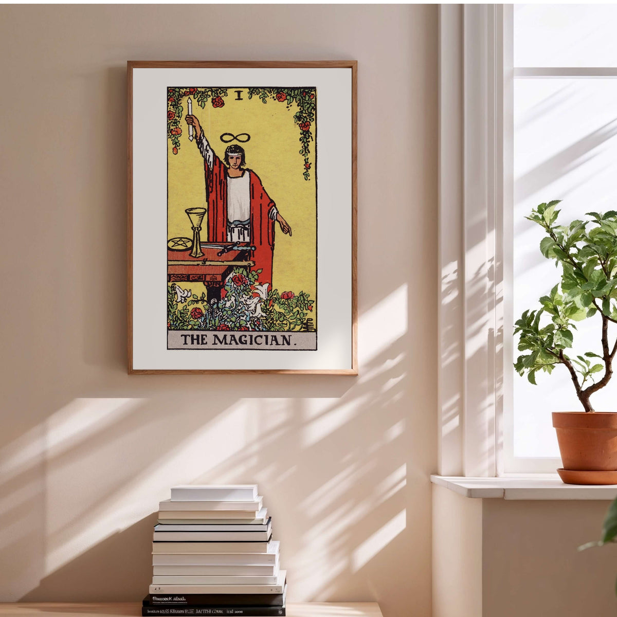 Le Bateleur - Arcane I du Tarot Rider-Waite, affiche encadrée au-dessus d'une pile de livres
