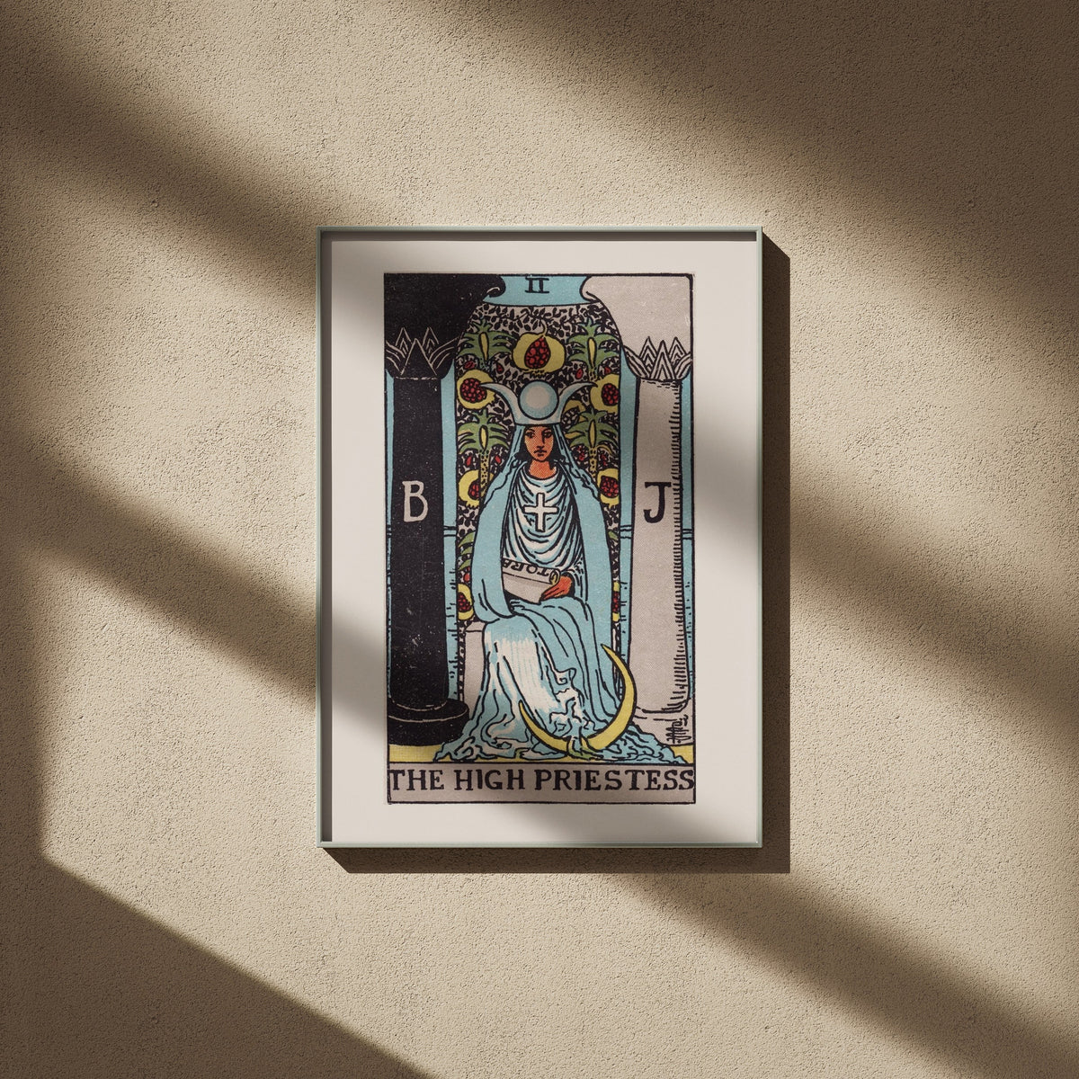 La Grande Prêtresse - Arcane II du Tarot Rider-Waite, affiche encadrée sur un mur beige, ombres de fenêtre