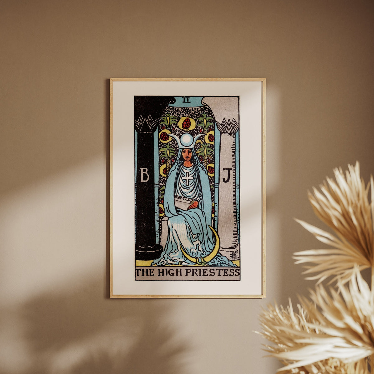 La Grande Prêtresse - Arcane II du Tarot Rider-Waite, affiche encadrée sur un mur beige, pampas au premier plan