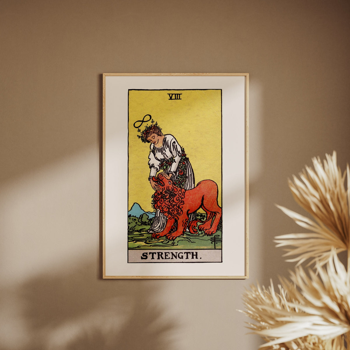 La Force - Arcane VIII du Tarot Rider-Waite, affiche encadrée sur un mur beige, pampas au premier plan