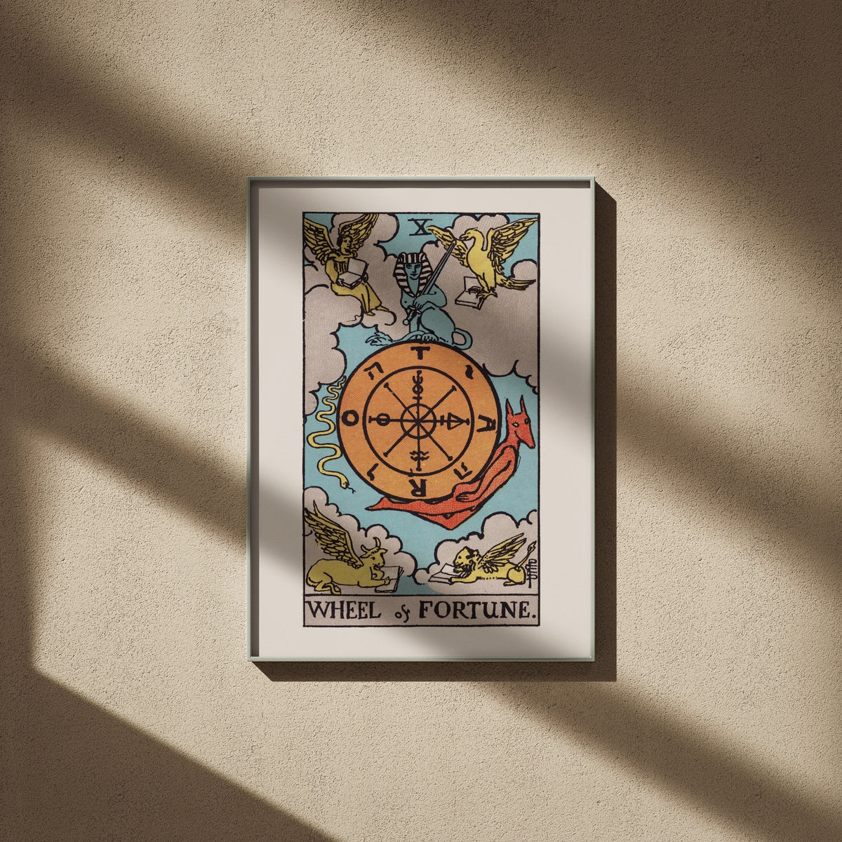 The Wheel of Fortune - Arcana X of the Rider-Waite Tarot, framed poster on a beige wall, window shadows