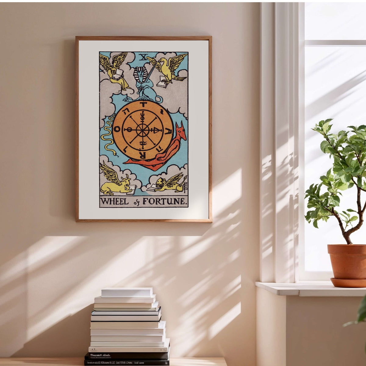 The Wheel of Fortune - Arcana X of the Rider-Waite Tarot, framed poster above a stack of books