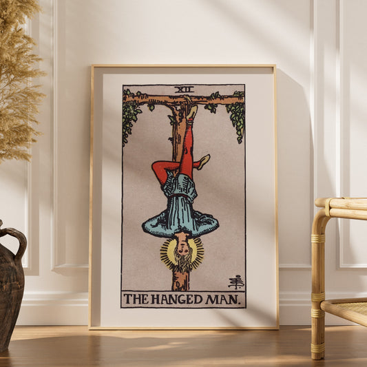 Le Pendu - Arcane XII du Tarot Rider-Waite, affiche encadrée dans un intérieur élégant, herbes séchées et chaise en rotin