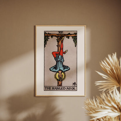 Arcana XII - The Hanged Man - Rider-Waite-Smith Tarot Poster, framed poster on a beige wall, pampas grass in the foreground