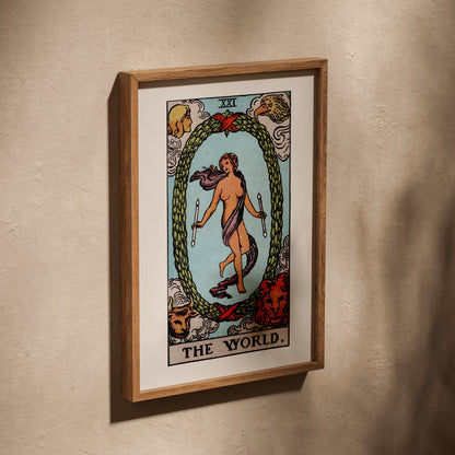 Le Monde - Arcane XXI du Tarot Rider-Waite, affiche dans un cadre en chêne posé de biais sur un mur texturé