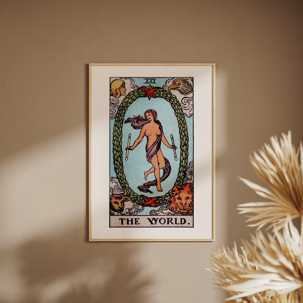 Le Monde - Arcane XXI du Tarot Rider-Waite, affiche encadrée sur un mur beige, pampas au premier plan