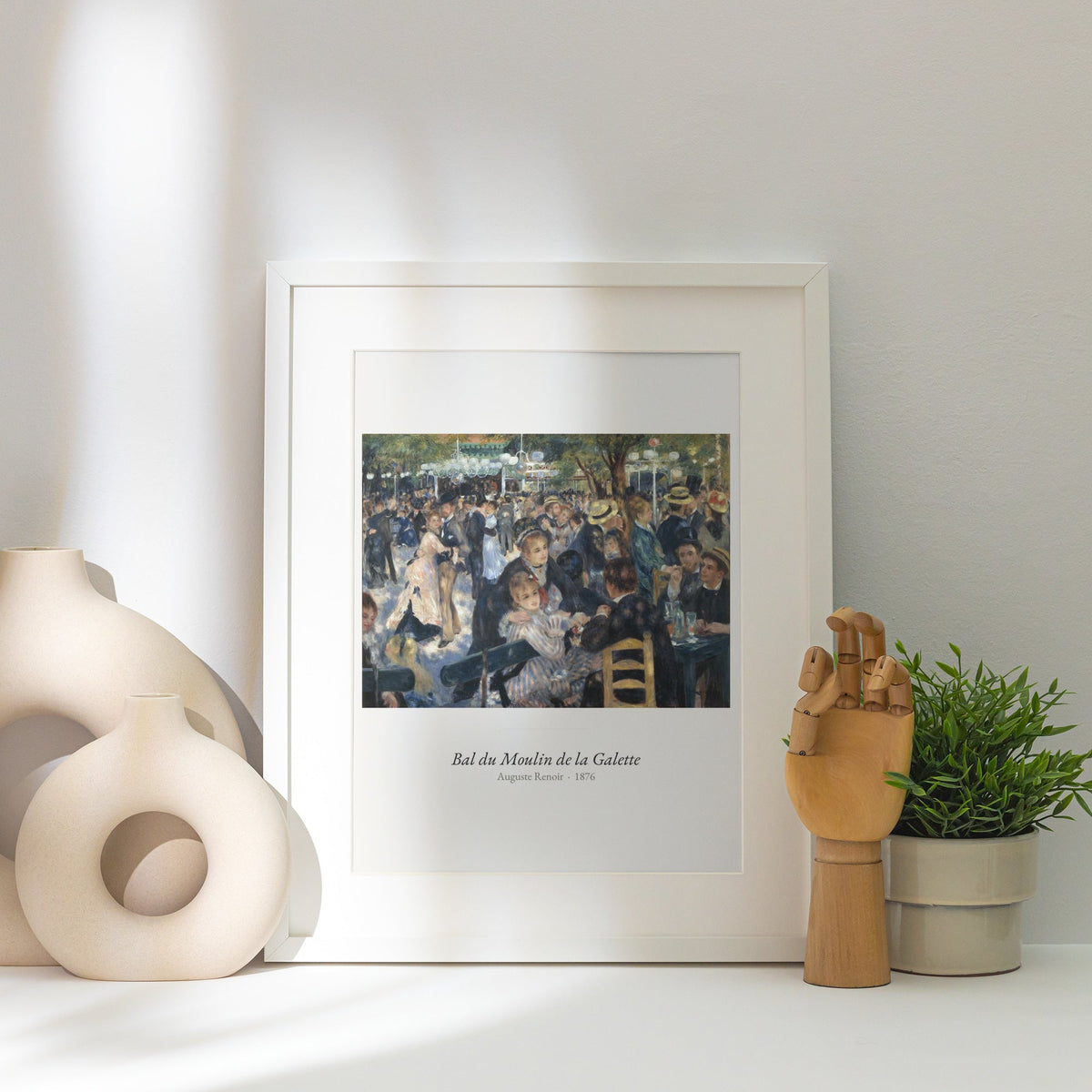 Bal du Moulin de la Galette, Renoir, affiche encadrée posée près d'un vase blanc, lumière rasante