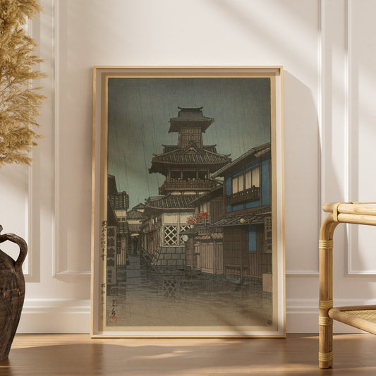Beffroi sous la Pluie, Okayama - Kawase Hasui, affiche encadrée dans un intérieur élégant, herbes séchées et chaise en rotin