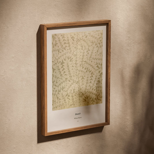 Branch, William Morris | Affiche Décorative Premium, affiche dans un cadre en chêne posé de biais sur un mur texturé