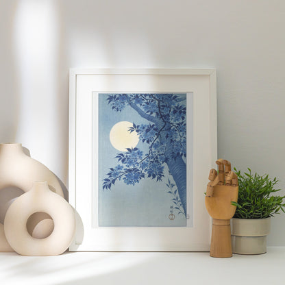 Cerisiers et Lune - Ohara Koson - Affiche Estampe Japonaise, affiche encadrée posée près d'un vase blanc, lumière rasante