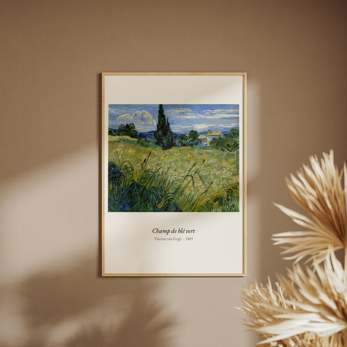 Champ de blé vert, Vincent van Gogh, affiche encadrée sur un mur beige, pampas au premier plan