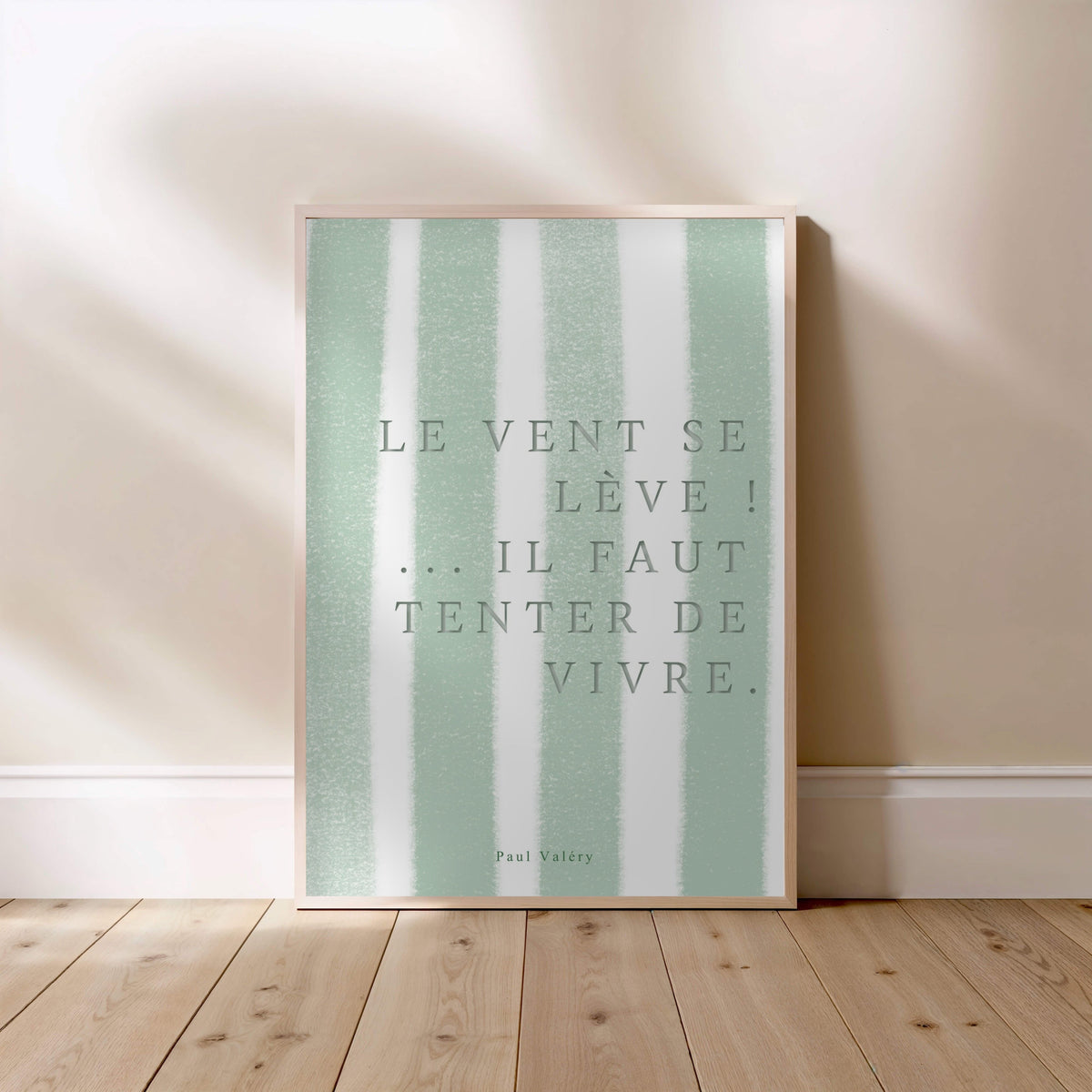 Affiche citation "Le vent se lève… il faut tenter de vivre", affiche encadrée posée au sol, cadre bois clair