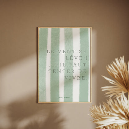 Affiche citation "Le vent se lève… il faut tenter de vivre", affiche encadrée sur un mur beige, pampas au premier plan