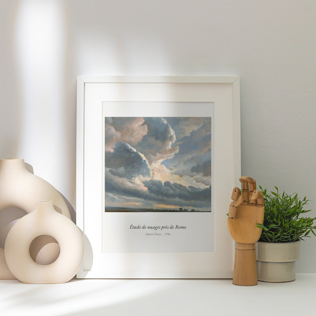 Étude de nuages près de Rome, Simon Denis, affiche encadrée posée près d'un vase blanc, lumière rasante