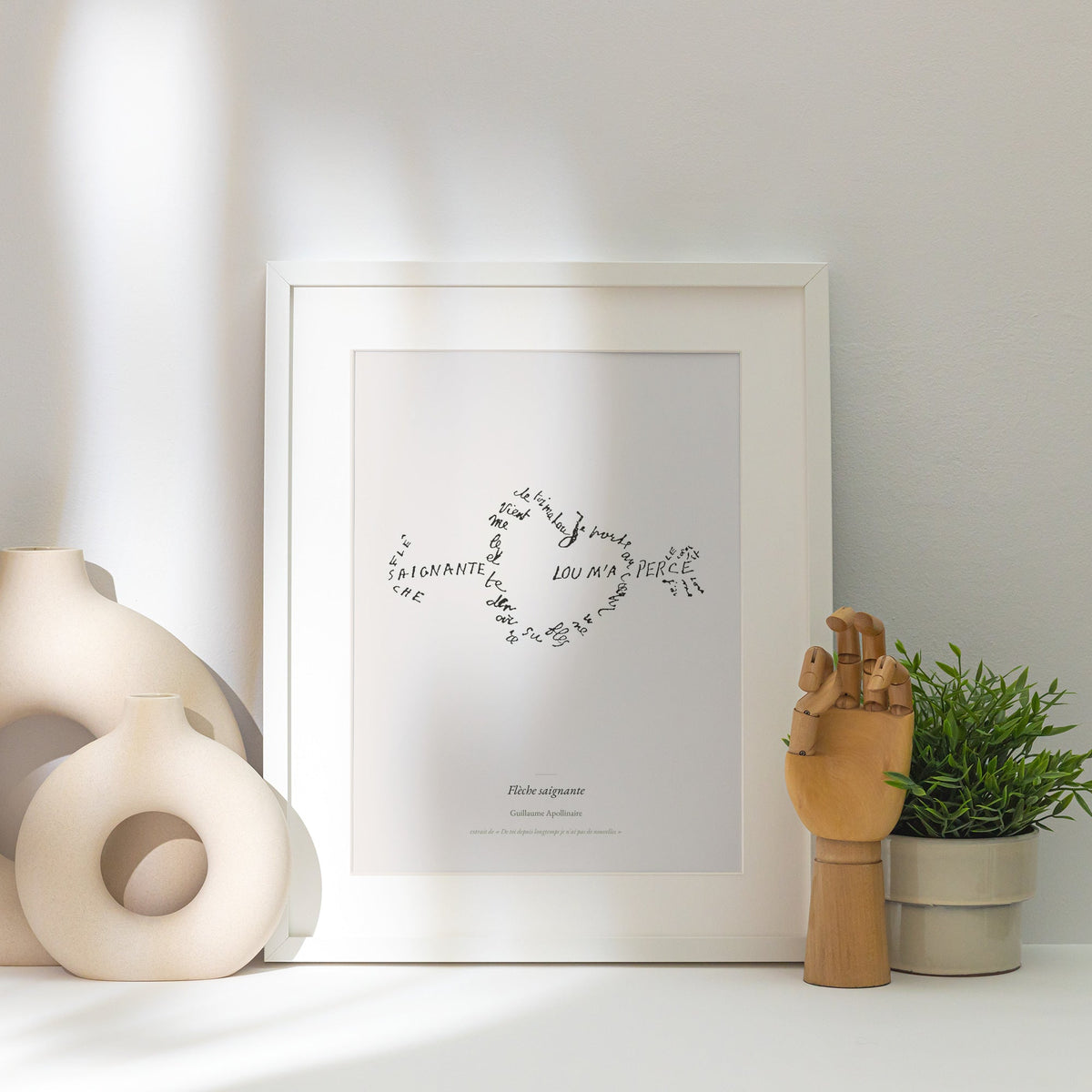 Flèche saignante - Apollinaire - Affiche Calligramme Amour, affiche encadrée posée près d'un vase blanc, lumière rasante