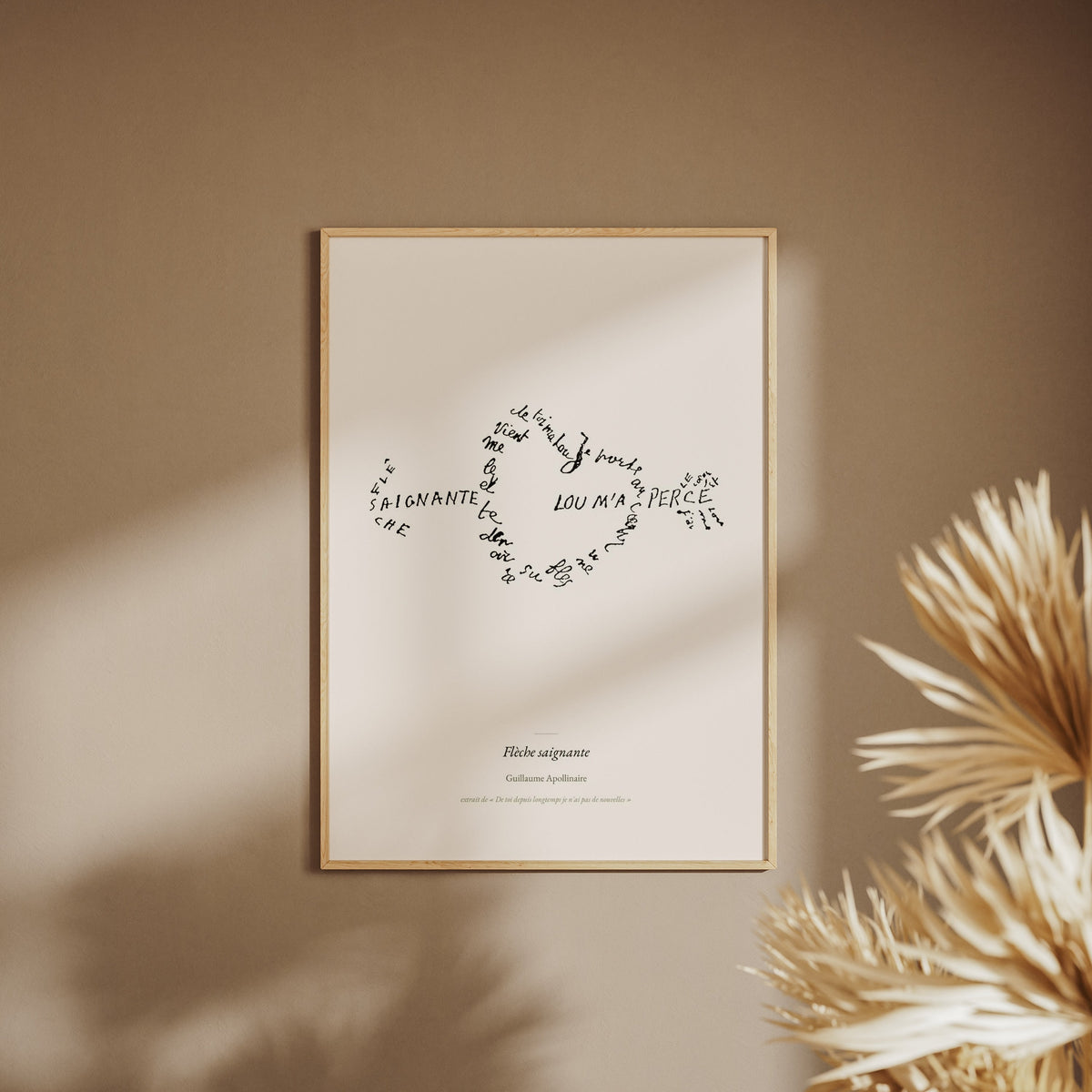 Flèche saignante - Apollinaire - Affiche Calligramme Amour, affiche encadrée sur un mur beige, pampas au premier plan