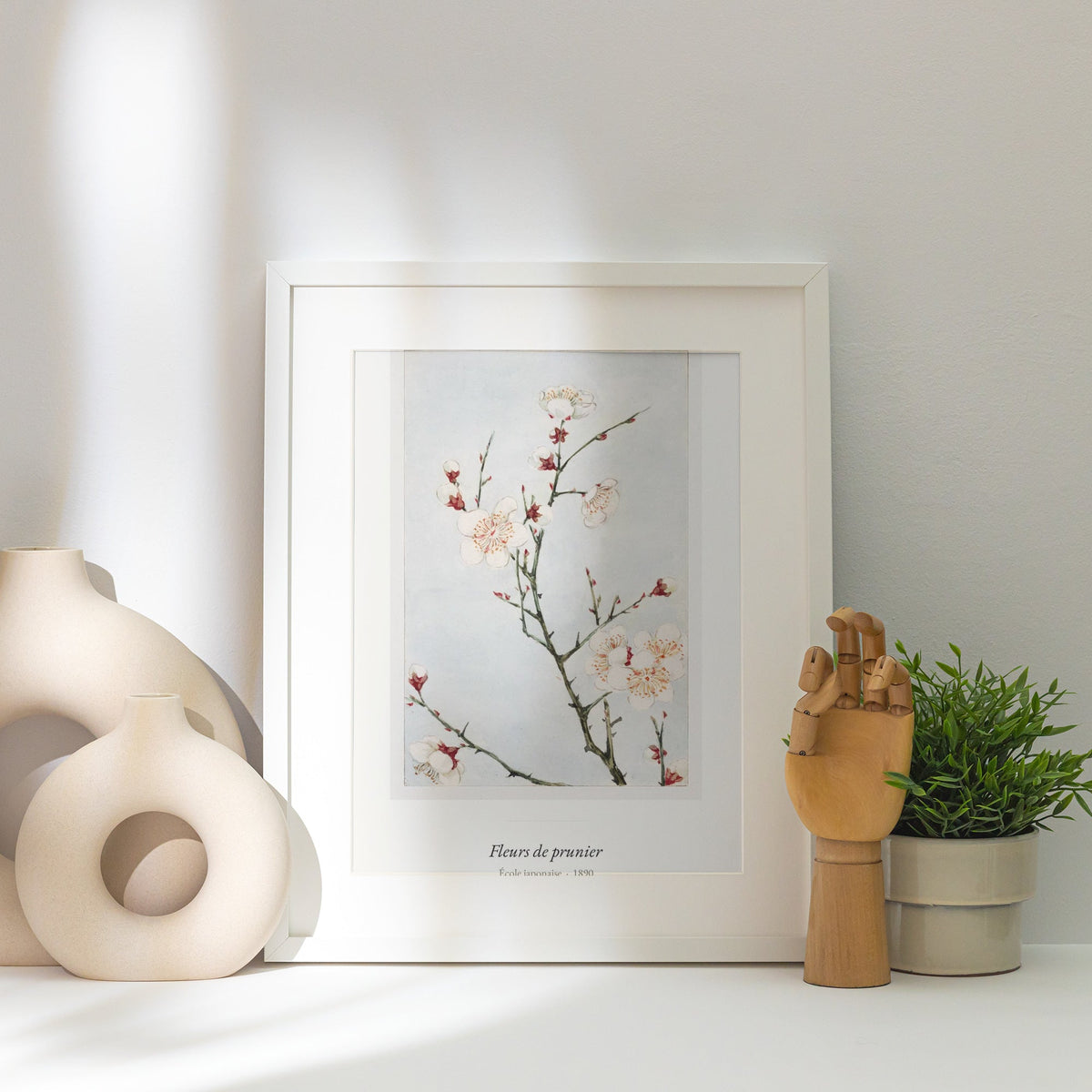 Fleurs de prunier, École japonaise, affiche encadrée posée près d'un vase blanc, lumière rasante