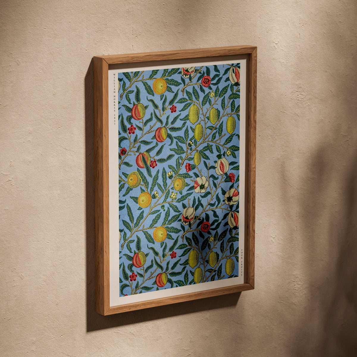 Four Fruits - William Morris - Affiche Arts & Crafts, affiche dans un cadre en chêne posé de biais sur un mur texturé