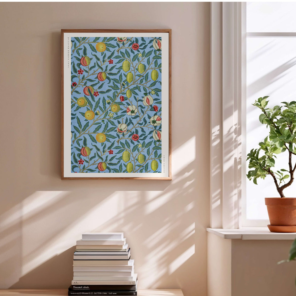Four Fruits - William Morris - Affiche Arts & Crafts, affiche encadrée au-dessus d'une pile de livres