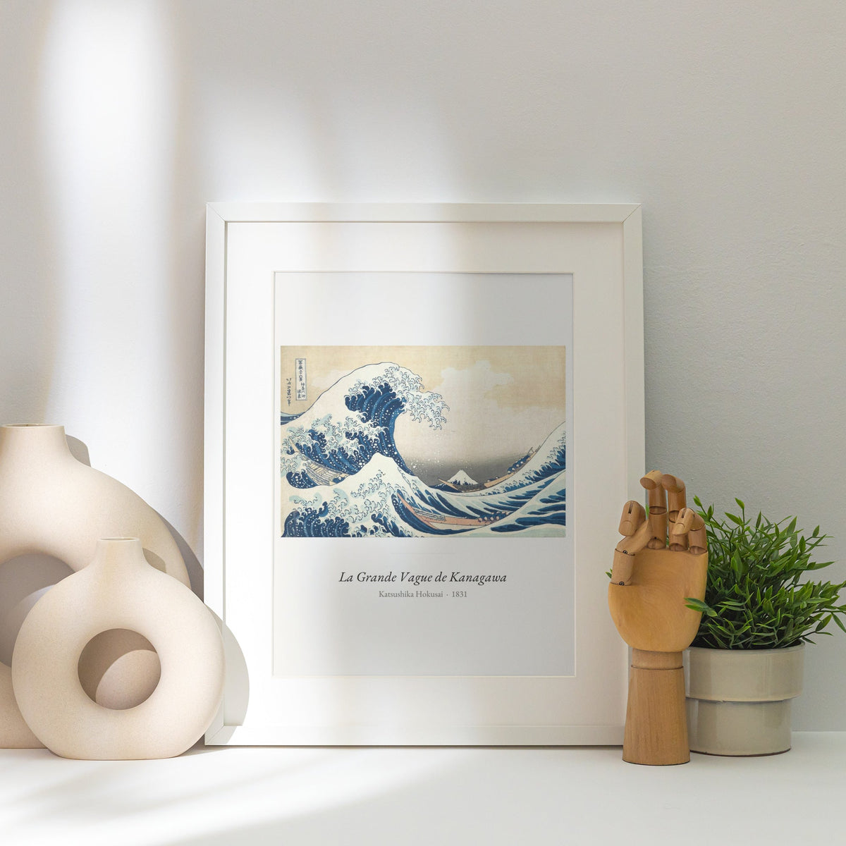 La Grande Vague de Kanagawa, Hokusai, affiche encadrée posée près d'un vase blanc, lumière rasante