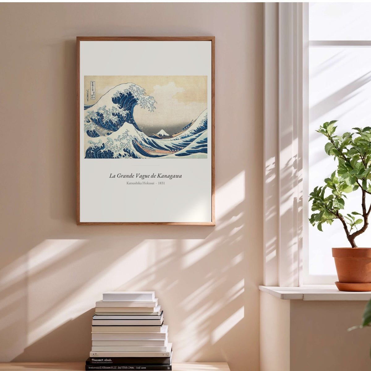 La Grande Vague de Kanagawa, Hokusai, affiche encadrée au-dessus d'une pile de livres