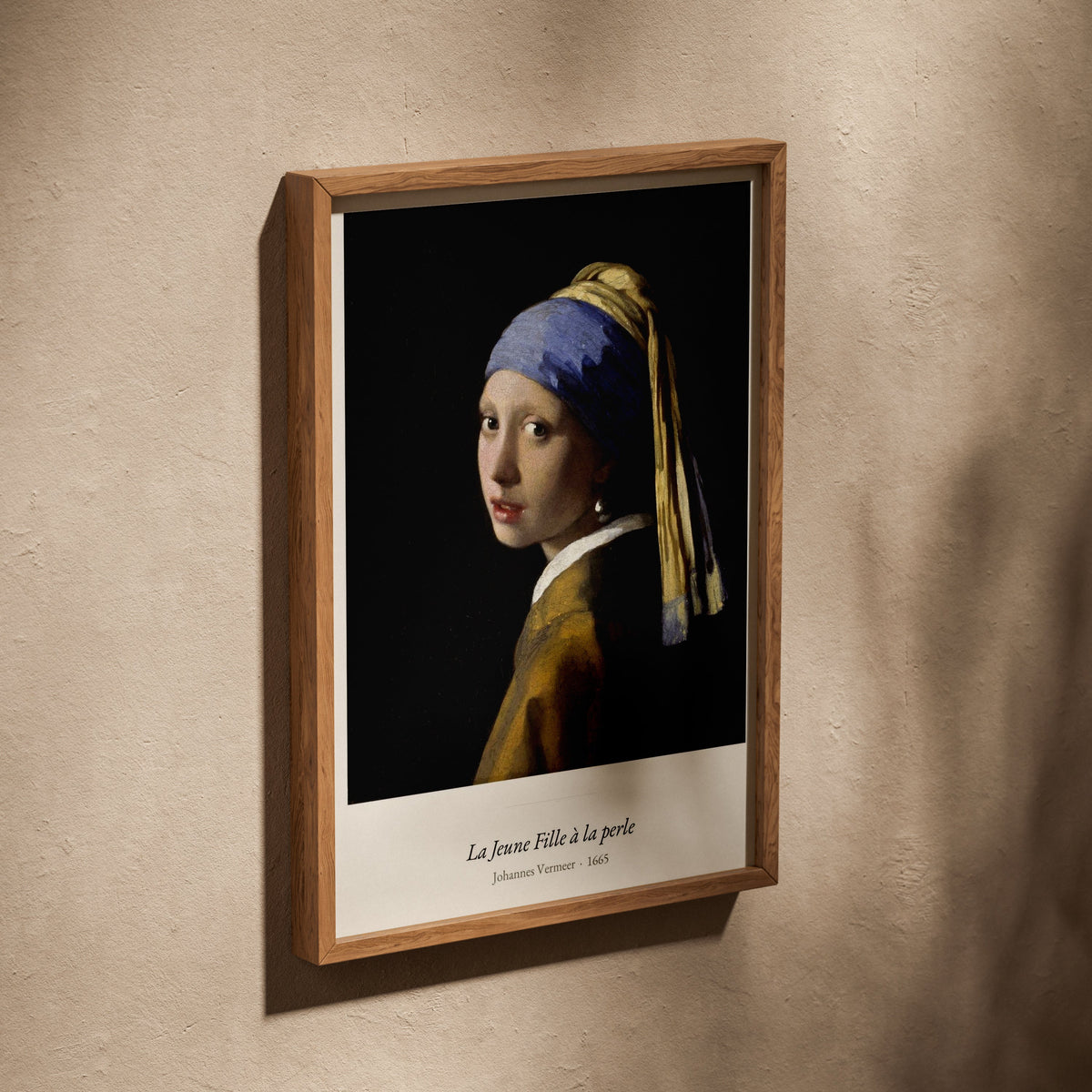 La Jeune Fille à la perle, Vermeer, affiche dans un cadre en chêne posé de biais sur un mur texturé
