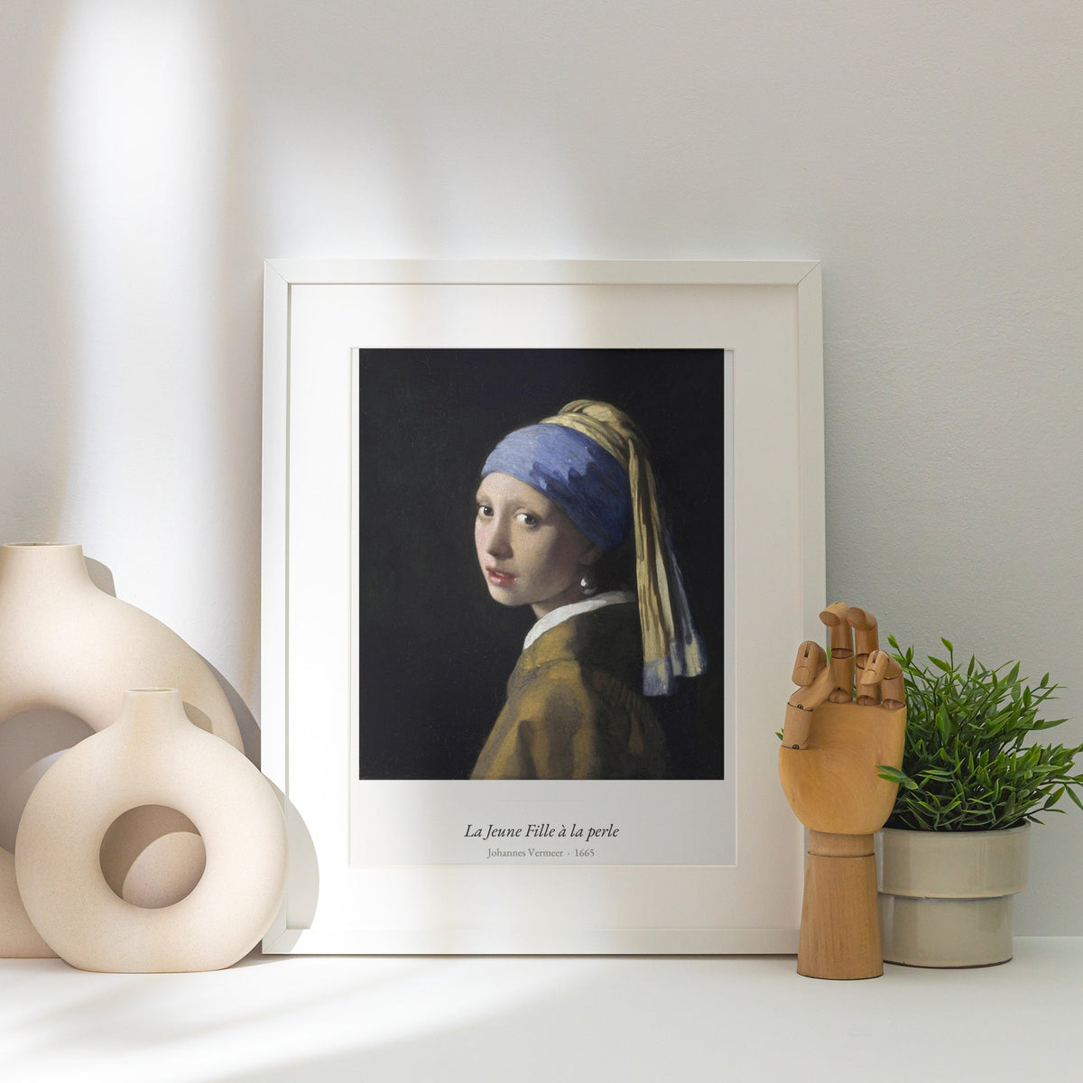 La Jeune Fille à la perle, Vermeer, affiche encadrée posée près d'un vase blanc, lumière rasante