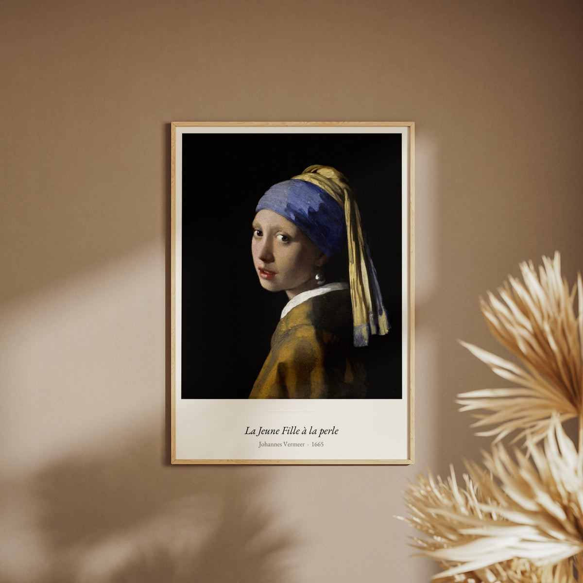 La Jeune Fille à la perle, Vermeer, affiche encadrée sur un mur beige, pampas au premier plan