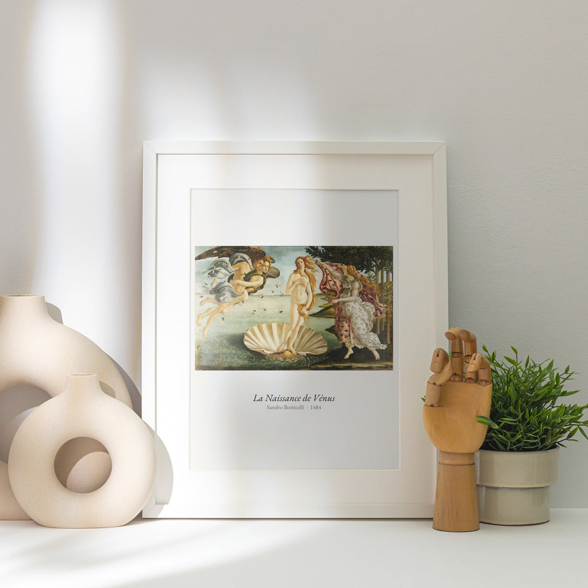 La Naissance de Vénus, Botticelli | Affiche Art Premium, affiche encadrée posée près d'un vase blanc, lumière rasante