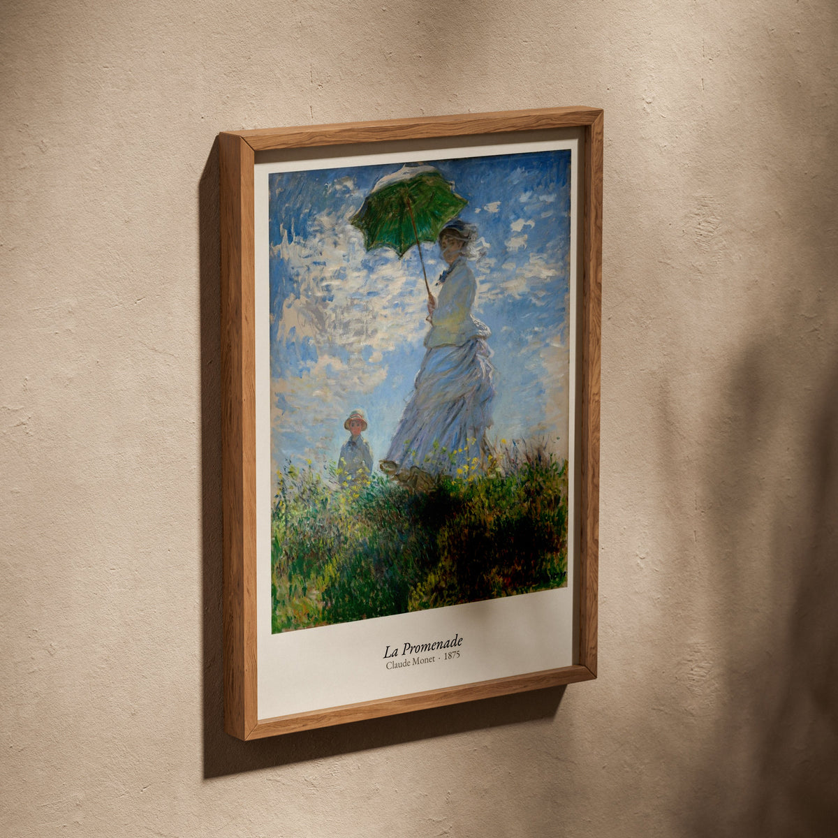 La Promenade, Claude Monet | Affiche Art Premium, affiche dans un cadre en chêne posé de biais sur un mur texturé
