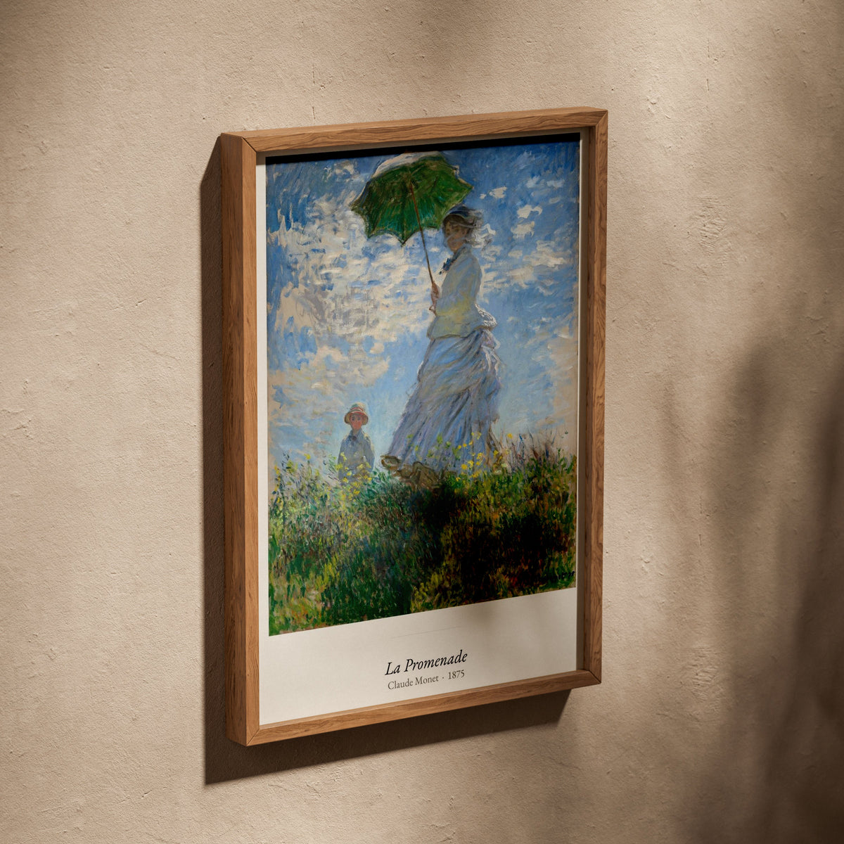 La Promenade, Claude Monet | Affiche Art Premium, affiche dans un cadre en chêne posé de biais sur un mur texturé