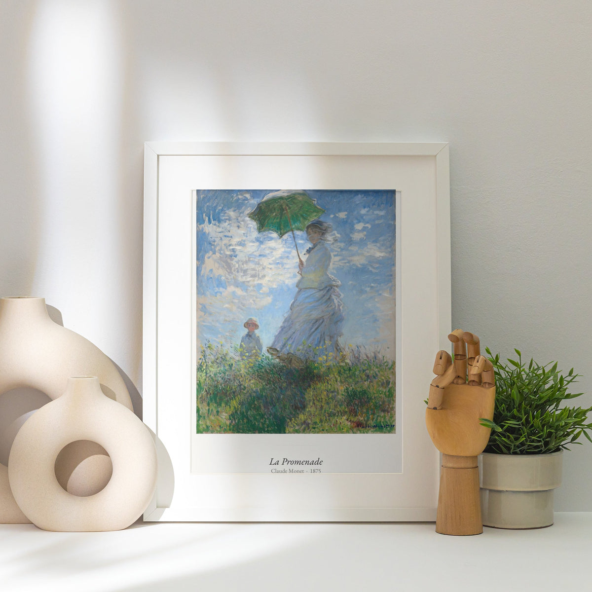 La Promenade, Claude Monet | Affiche Art Premium, affiche encadrée posée près d'un vase blanc, lumière rasante