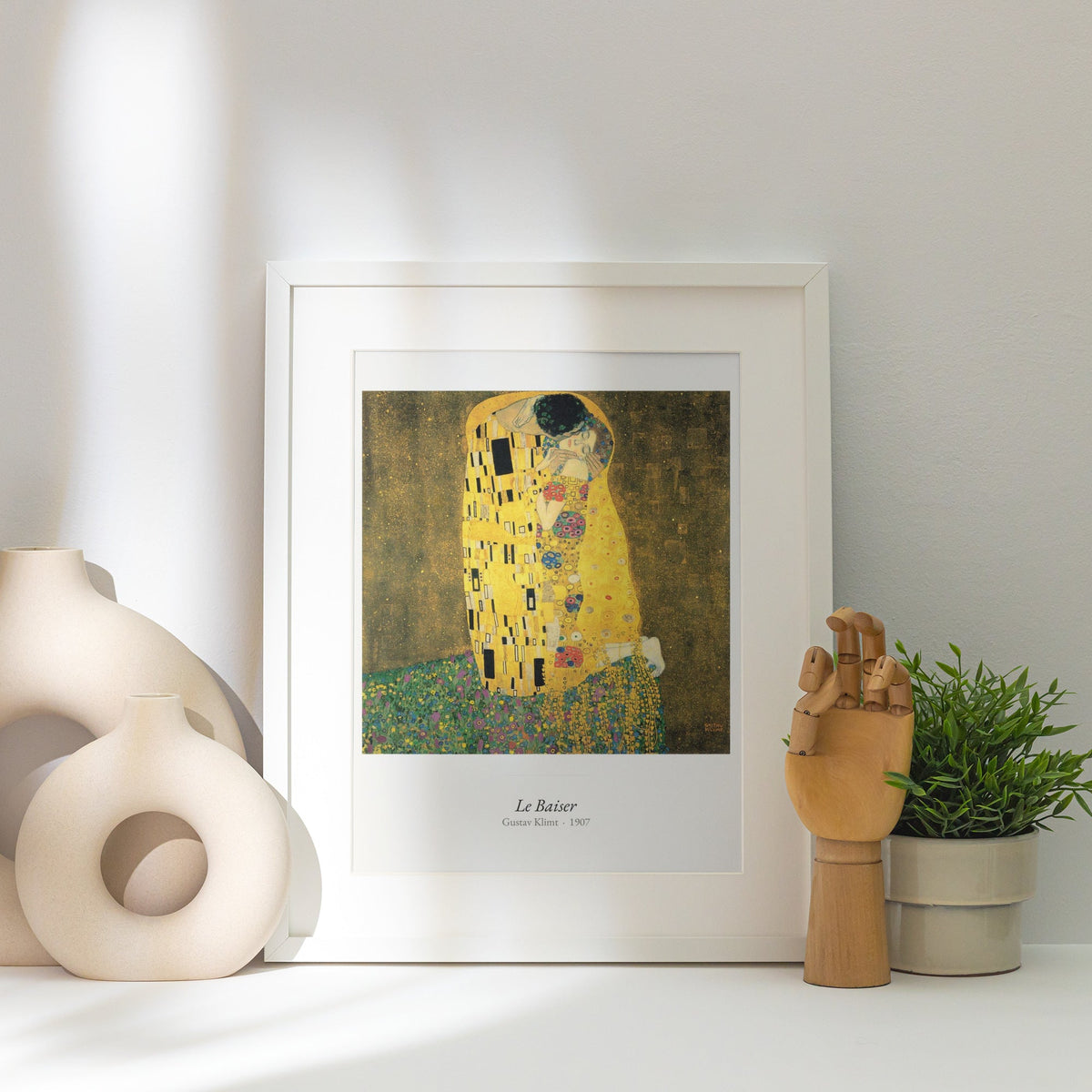 Le Baiser, Gustav Klimt | Affiche Art Premium, affiche encadrée posée près d'un vase blanc, lumière rasante
