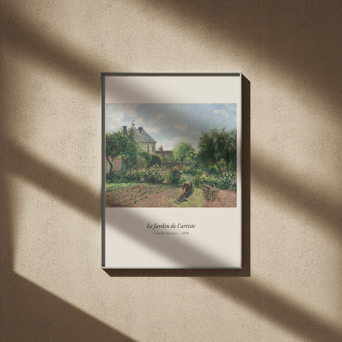 Le Jardin de l'artiste, Camille Pissarro, affiche encadrée sur un mur beige, ombres de fenêtre