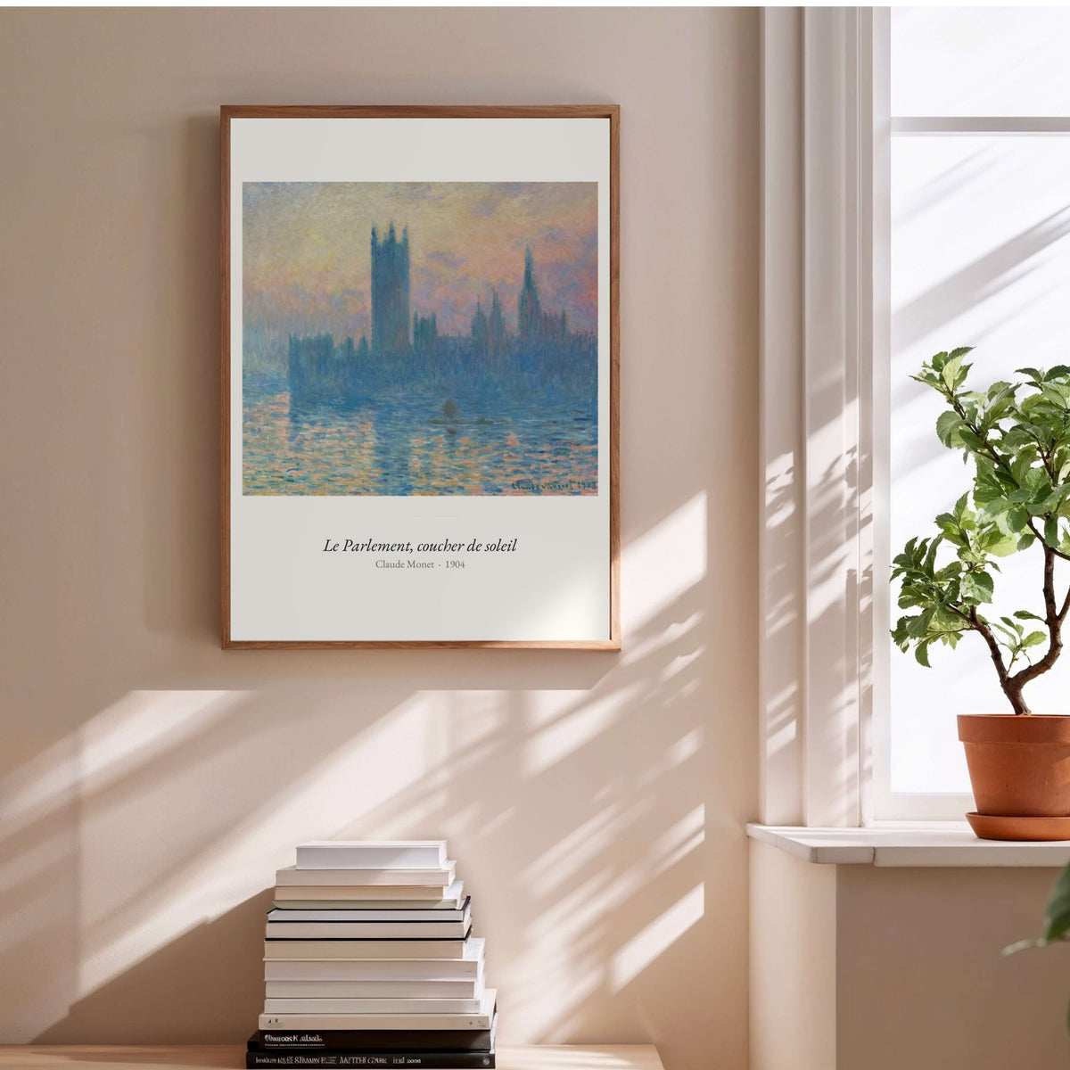 Le Parlement, coucher de soleil, Monet, affiche encadrée au-dessus d'une pile de livres