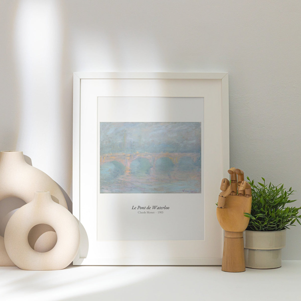 Le Pont de Waterloo, Claude Monet | Affiche Art Premium, affiche encadrée posée près d'un vase blanc, lumière rasante