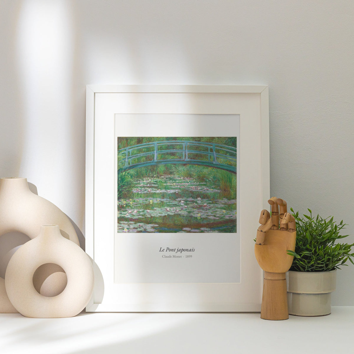 Le Pont japonais, Claude Monet | Affiche Art Premium, affiche encadrée posée près d'un vase blanc, lumière rasante
