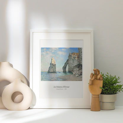 Les Falaises d'Étretat, Claude Monet, affiche encadrée posée près d'un vase blanc, lumière rasante