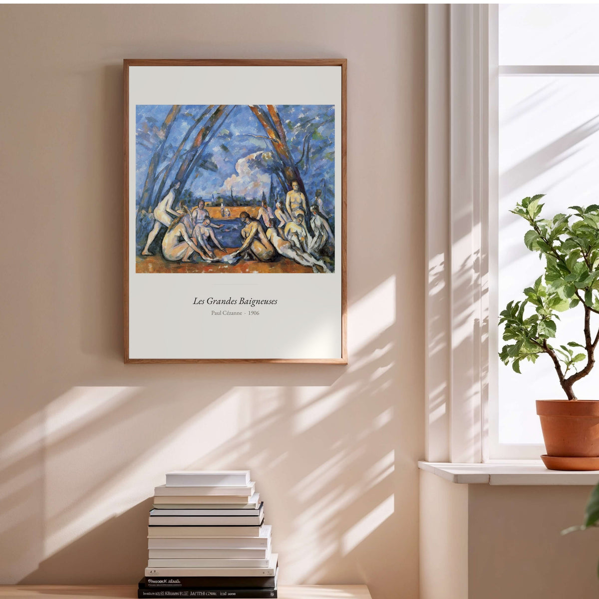 Les Grandes Baigneuses, Paul Cézanne, affiche encadrée au-dessus d'une pile de livres